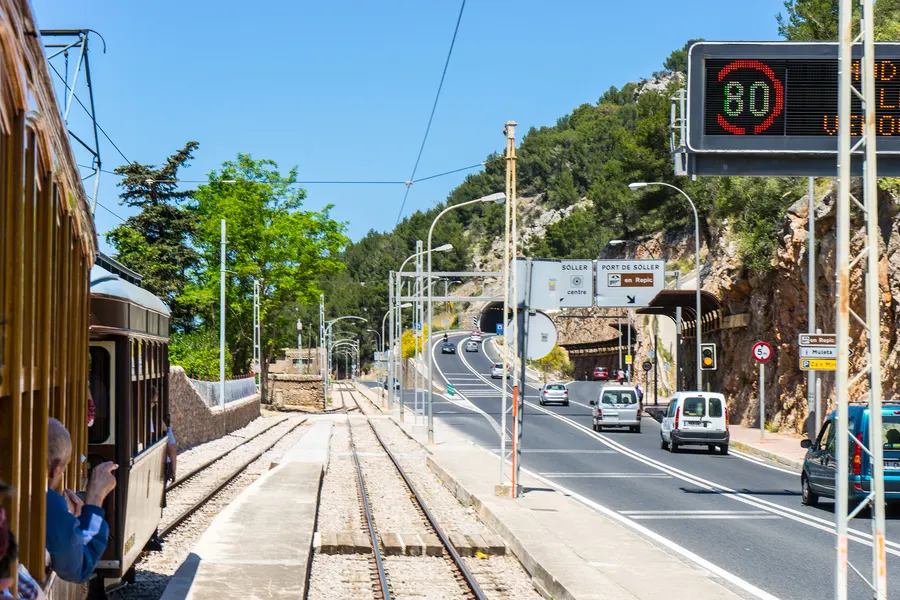 Blick aus einem Wagen der Straßenbahn auf das Gleis, das neben der Landstraße zwischen Sóller und dem Hafen verläuft.
