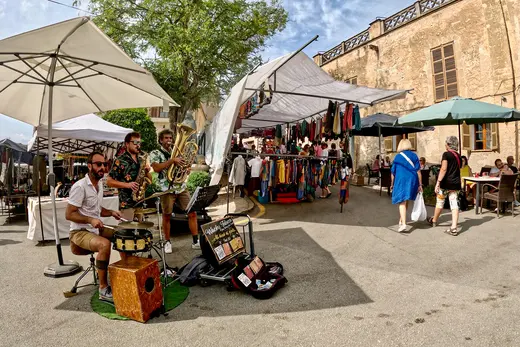 Marktstände unter Schirmen auf einem mallorquinischen Marktplatz.